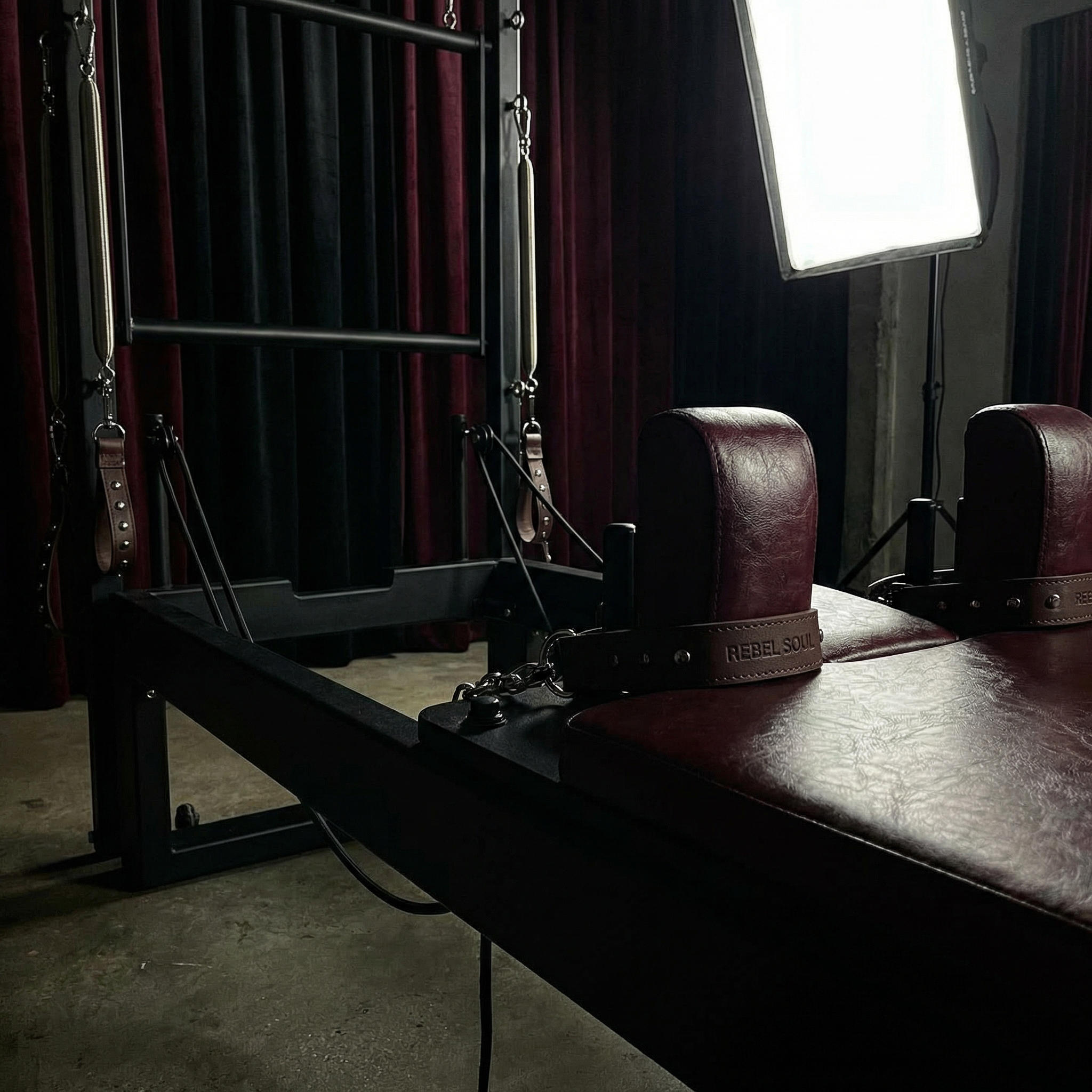 An Oxblood vinyl reformer carriage with antique brass hardware.